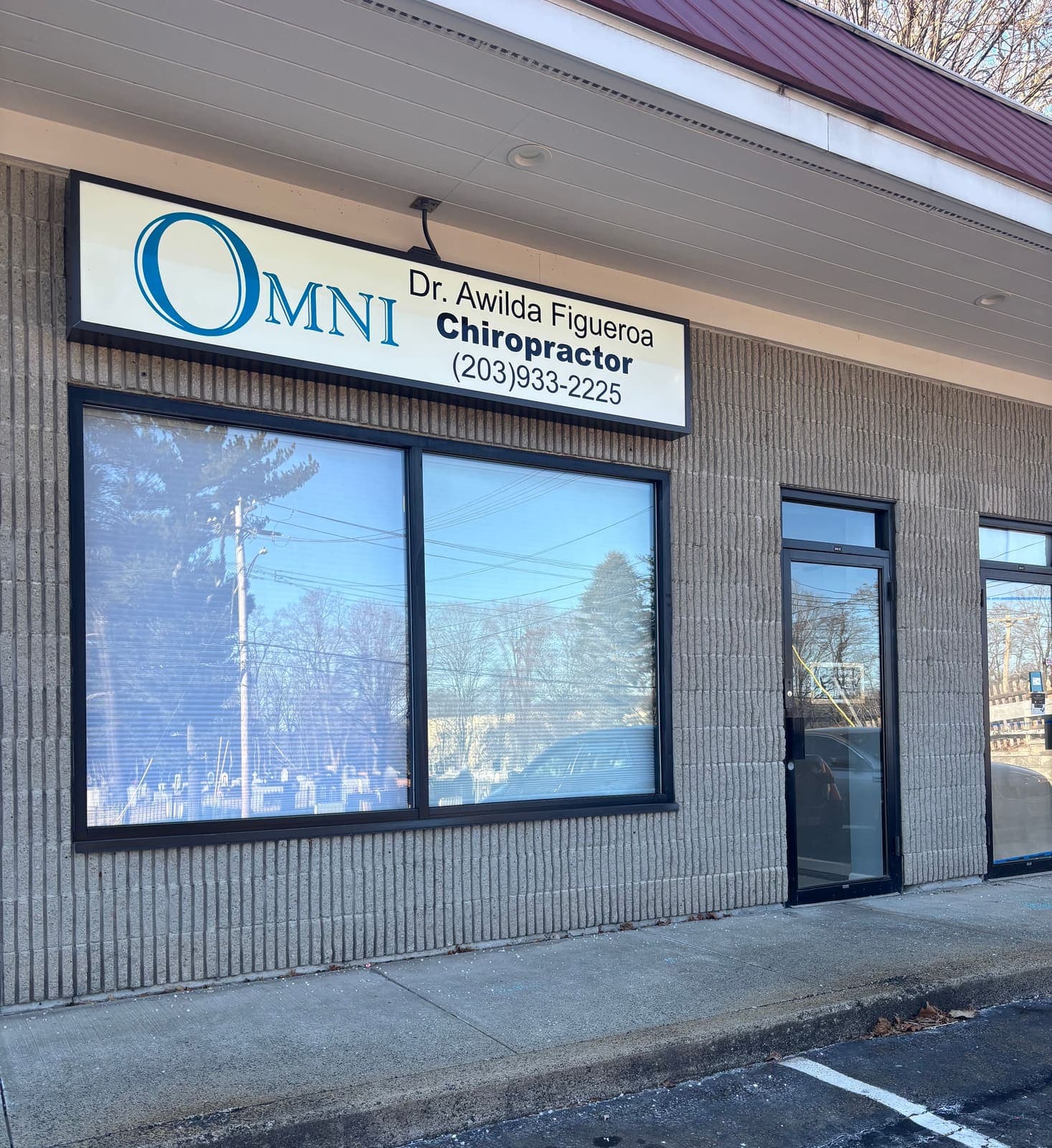 La entrada de la oficina de Omni en West Haven, en 560 Forest Road, con el letrero quiropráctico de Omni de la Dra. Awilda Figueroa sobre el local